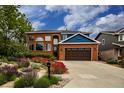 Inviting red brick home with blue accents, boasting professional landscaping and a spacious driveway at 3142 Captains Ln, Longmont, CO 80503