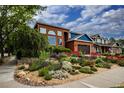 Charming brick and blue home with mature landscaping and a lush front yard, showcasing curb appeal at 3142 Captains Ln, Longmont, CO 80503