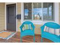 Inviting front porch with blue wicker chairs and a rug at 2602 S Lafayette St, Denver, CO 80210