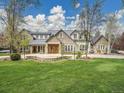 Beautiful stone house with a metal roof and manicured lawn at 1075 E Oxford Ln, Cherry Hills Village, CO 80113