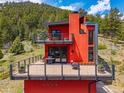 Unique red mountain home with expansive deck, perfect for enjoying the serene natural surroundings at 5896 Peregrine Trl, Golden, CO 80403