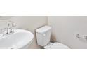 Clean bathroom with white sink, toilet, and grab bars at 8869 Sedalia St, Commerce City, CO 80022