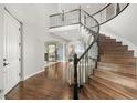 Elegant foyer with a curved staircase, hardwood floors, and a view into the formal dining room at 12532 Daniels Gate Dr, Castle Pines, CO 80108