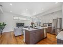 Bright living room featuring a large kitchen island, stainless steel appliances, and hardwood floors at 1216 Perry St, Denver, CO 80204