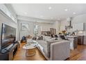 Open concept living room boasts hardwood floors, recessed lighting, and an adjacent modern kitchen at 1216 Perry St, Denver, CO 80204