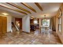 Spacious dining room featuring a skylight, exposed beams, and terra cotta flooring adjacent to the kitchen for easy access at 3722 Monterey Pl, Boulder, CO 80301
