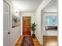 Inviting hallway with hardwood floors, leading to a cozy living area and bedroom at 13561 W Alaska Pl, Lakewood, CO 80228
