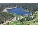 Scenic aerial view of a vast lake surrounded by lush greenery, golf course, and residential area at 30094 Upper Bear Creek Rd, Evergreen, CO 80439