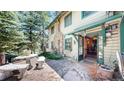 Inviting home exterior featuring a stone patio, rustic accents, and a welcoming, forest vibe at 30094 Upper Bear Creek Rd, Evergreen, CO 80439
