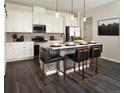 Modern kitchen with island and stainless steel appliances at 6153 N Ceylon St # 306, Denver, CO 80249