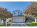 Charming blue two-story home with a gray garage and brick accents under a clear sky at 11580 Depew Ct, Westminster, CO 80020
