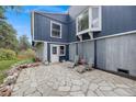 Stone patio with chairs and table leading to back door at 8783 S Ault Ln, Morrison, CO 80465