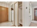 Apartment hallway featuring a closet, entry door, and view into the kitchen at 13800 E Marina Dr # 112, Aurora, CO 80014