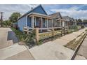 Exterior view of a charming blue house with a well-maintained yard and a quaint wooden fence at 66 E 45Th Ave, Denver, CO 80216