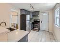 Updated kitchen with stainless steel appliances, ample cabinet space, and tile flooring at 66 E 45Th Ave, Denver, CO 80216
