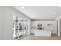 Modern kitchen with white cabinets, stainless steel appliances, and a large sliding glass door to the backyard at 1324 Sienna Peak Cir, Erie, CO 80516