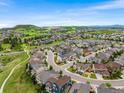 Aerial view of a well-planned community with lush green spaces, winding roads, and diverse home styles under a blue sky at 2679 Leafdale Cir, Castle Rock, CO 80109