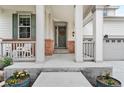 Front porch with white columns, space for seating, decorative plants, and a gray front door with wreath detail at 2679 Leafdale Cir, Castle Rock, CO 80109