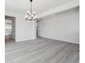 Spacious living room featuring a chandelier, light wood-look floors, and neutral walls at 4741 Twelve Oaks Way, Castle Rock, CO 80104
