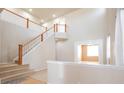 Bright foyer with high ceilings, wooden staircase, and light neutral paint create a grand entrance at 21286 E Nassau Ave, Aurora, CO 80013