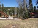 Secluded backyard featuring a patio with seating and a small shed, offering a peaceful outdoor space at 10438 Sunlight Ln, Conifer, CO 80433