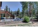 Relaxing backyard patio with outdoor seating, stone pavers, and lush landscaping creating a serene retreat at 10438 Sunlight Ln, Conifer, CO 80433