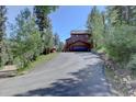 Charming mountain home with an attached garage and driveway, surrounded by lush greenery and natural beauty at 10438 Sunlight Ln, Conifer, CO 80433