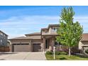 Traditional two story home featuring a two-car garage, neutral colored siding, and a well-maintained front lawn at 16062 Red Bud Loop, Parker, CO 80134