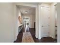 Inviting hallway features wood flooring, neutral walls, and stylish decor leading into open living spaces at 16062 Red Bud Loop, Parker, CO 80134