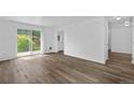 Bright living room featuring wood-look floors and sliding glass doors to the backyard at 1235 S Benton St, Lakewood, CO 80232