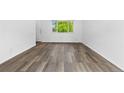 Clean and modern living room features wood-look floors, bright, neutral walls, and a large window at 1235 S Benton St, Lakewood, CO 80232