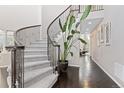 Elegant entryway with a curved staircase, wrought iron railing, and dark hardwood floors at 6728 S Catawba Way, Aurora, CO 80016
