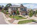 Charming two-story home with a three-car garage and well-manicured lawn on a sunny day at 6728 S Catawba Way, Aurora, CO 80016