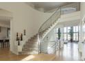 Bright foyer featuring a winding staircase with unique railings, hardwood floors, and an open floor plan at 98 Glenmoor Ln, Cherry Hills Village, CO 80113