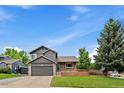 Inviting exterior view with lush lawn, brick details, two-car garage, and serene surroundings at 10859 W Fair Ave, Littleton, CO 80127