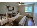Comfortable bedroom featuring a plush bed with decorative pillows, wood floors, and a window view at 17361 E Mansfield Ave # 532R, Aurora, CO 80013