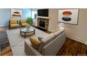 Cozy living room with a stone fireplace, neutral walls, a patterned rug, and modern furniture at 17361 E Mansfield Ave # 532R, Aurora, CO 80013