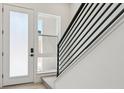 Modern entryway with white door, large window, and black railing staircase at 11481 E Briarwood Cir, Centennial, CO 80112