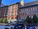 Street-level perspective of a brick building with a view of other residential structures at 1555 California St # 302, Denver, CO 80202