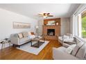 Spacious living room with hardwood floors, a brick fireplace, and natural light from large windows at 8100 W 8Th Ave, Lakewood, CO 80214