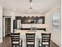 This kitchen features a large island with bar stool seating and stylish pendant lighting at 12734 E 104Th Pl, Commerce City, CO 80022
