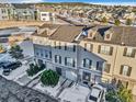 Three-story townhouses with attached garages and snowy landscaping at 909 Burning Bush Pt, Monument, CO 80132