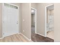 Bright entryway with hardwood floors, leading to the bathroom and carpeted rooms at 15525 Quince Cir, Thornton, CO 80602