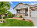 Close up of a well-maintained front yard with lush green grass and beautiful landscaping at 15525 Quince Cir, Thornton, CO 80602