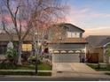 Charming two-story home features a well-maintained lawn, a two-car garage, and attractive landscaping at 6055 W Progress Ave, Littleton, CO 80123