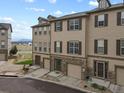 Three-story townhome complex with mountain views and surrounding landscape at 985 Burning Bush Pt, Monument, CO 80132