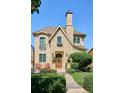 Charming stone home with blue-trimmed windows, a stone chimney, and manicured landscaping at 639 S Williams St, Denver, CO 80209