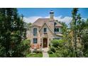 A beautiful stone home with blue window trim, front porch seating, and mature landscaping at 639 S Williams St, Denver, CO 80209