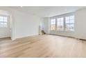 Bright and airy living room with hardwood floors, large windows, and neutral walls at 8867 Waterleaf Ln, Littleton, CO 80125