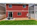 Backyard with a patio seating area, rock landscaping, small grass area, and red wood-panel siding at 5558 Malta St, Denver, CO 80249
